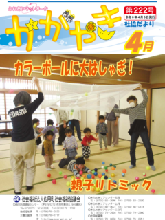 社協だよりかがやき222号 表紙は、カラーボールに大はしゃぎで遊ぶ親子とボランティアが写る、親子リトミックの写真を掲載しています